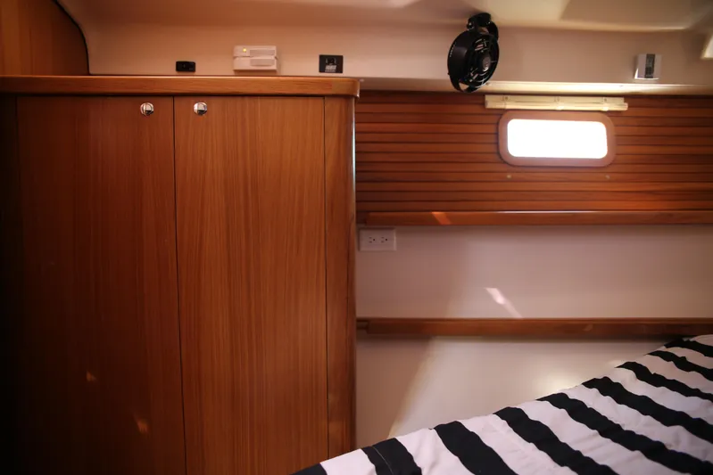 Platypus Yacht Photos Pics Interior cabin of 2014 Catalina 445 sailboat with wooden cabinetry and striped bedding.