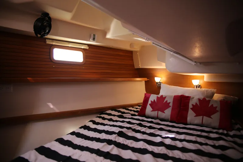 Platypus Yacht Photos Pics Cozy cabin interior of 2014 Catalina 445 sailboat with striped bedding and maple leaf pillows.