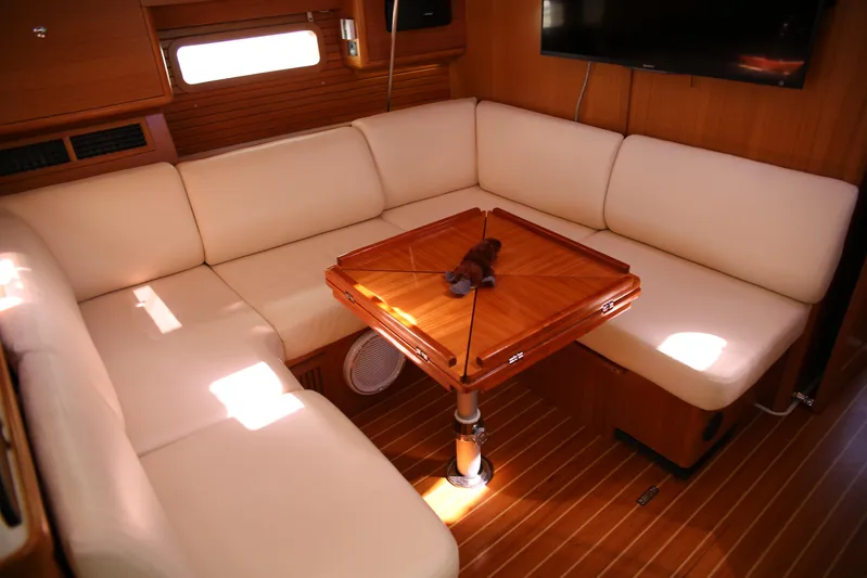 Platypus Yacht Photos Pics Interior of 2014 Catalina 445 yacht with white seating and wooden table.