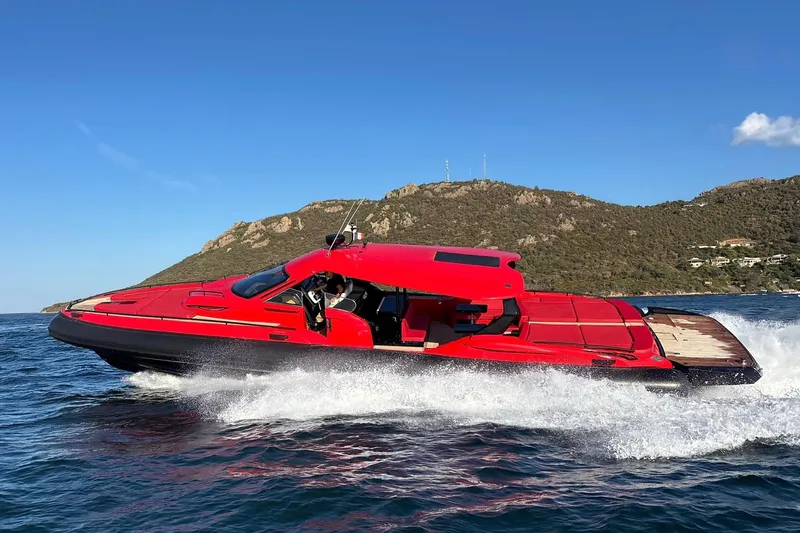  Yacht Photos Pics Red 2015 SACS Strider 19 speedboat cruising on the ocean near a rocky coastline.