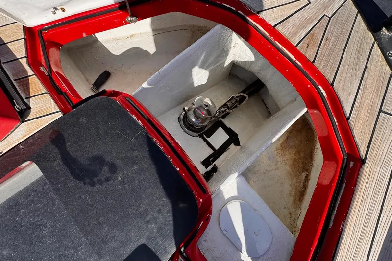  Yacht Photos Pics Open storage compartment on 2015 SACS Strider 19 boat with red trim and wooden deck.
