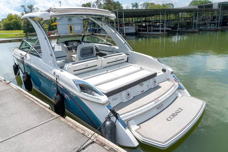  Yacht Photos Pics 2023 Cobalt R30 boat docked at marina, showcasing sleek design and spacious seating.