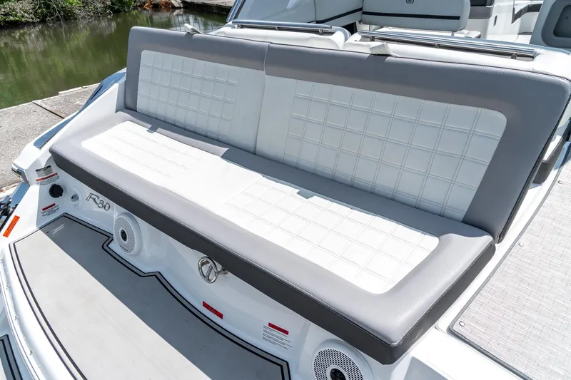  Yacht Photos Pics 2023 Cobalt R30 boat with stylish white and gray seating, docked by the water.