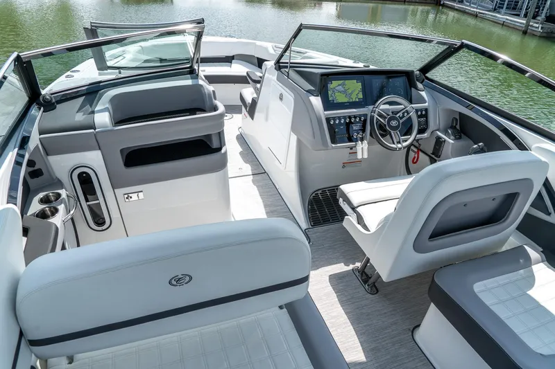  Yacht Photos Pics 2023 Cobalt R30 boat interior with modern dashboard and seating, docked on calm water.