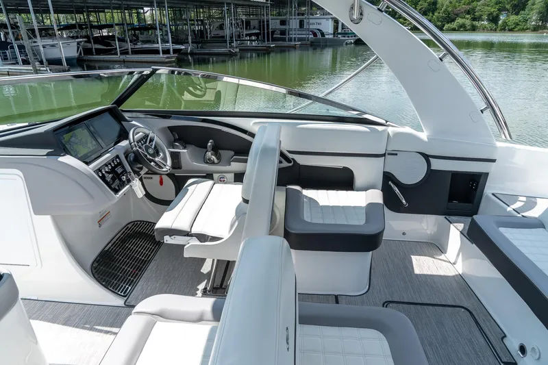  Yacht Photos Pics 2023 Cobalt R30 boat interior with modern helm and seating, docked by a serene lake.