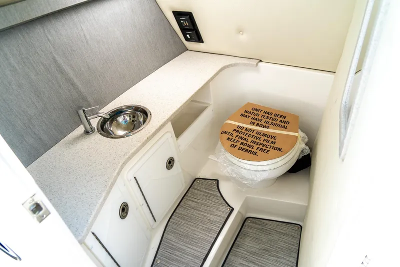  Yacht Photos Pics 2023 Cobalt R30 boat interior with sink and toilet, featuring modern design and functionality.