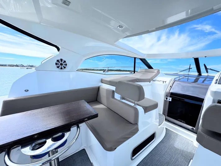 Ganesha Yacht Photos Pics Interior of 2016 Jeanneau 36 Leader yacht with seating and table, under a clear blue sky.