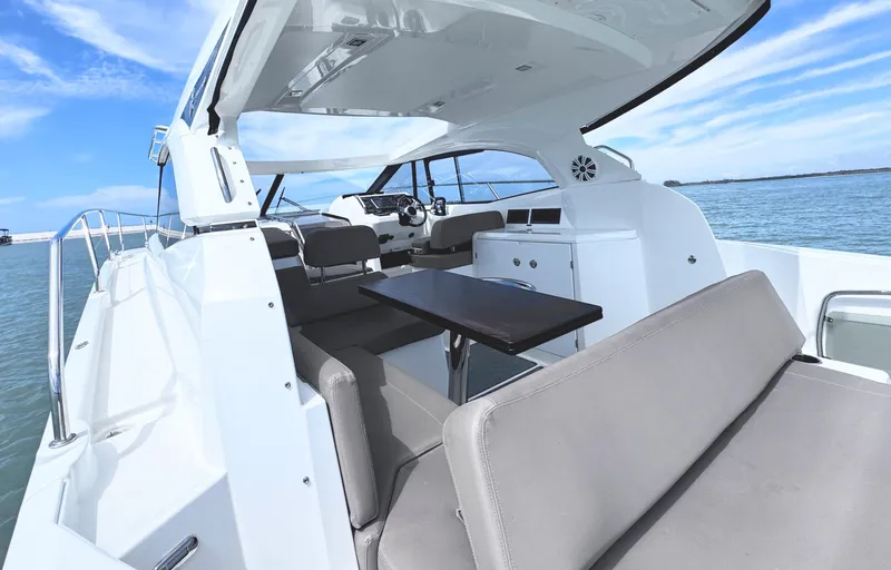 Ganesha Yacht Photos Pics 2016 Jeanneau 36 Leader yacht interior with seating and table, on calm water.