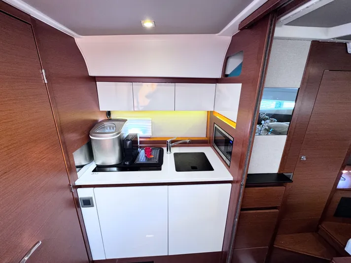 Ganesha Yacht Photos Pics Interior of 2016 Jeanneau 36 Leader yacht kitchen with modern appliances and wood finish.