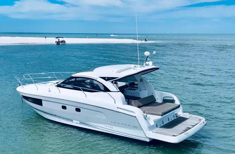 Ganesha Yacht Photos Pics 2016 Jeanneau 36 Leader yacht on serene blue waters near a sandy beach.