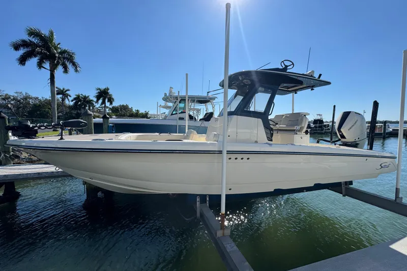  Yacht Photos Pics 2025 Scout 281 XSS boat docked in sunny marina with palm trees.
