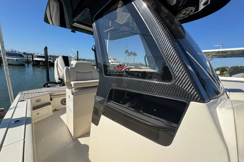  Yacht Photos Pics 2025 Scout 281 XSS boat with carbon fiber detailing docked at a marina.