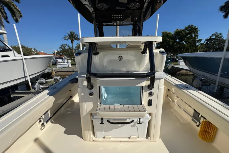  Yacht Photos Pics 2025 Scout 281 XSS boat interior with storage and seating, docked under clear blue sky.