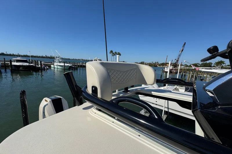  Yacht Photos Pics 2025 Scout 281 XSS boat helm with luxurious seating at a marina.