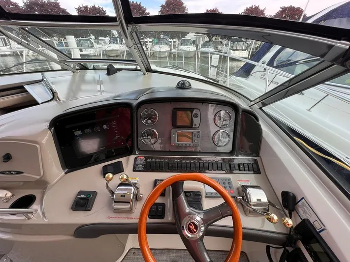 Cayetana Yacht Photos Pics 2004 Sea Ray 390 Sundancer helm with gauges, controls, and wooden steering wheel at marina.