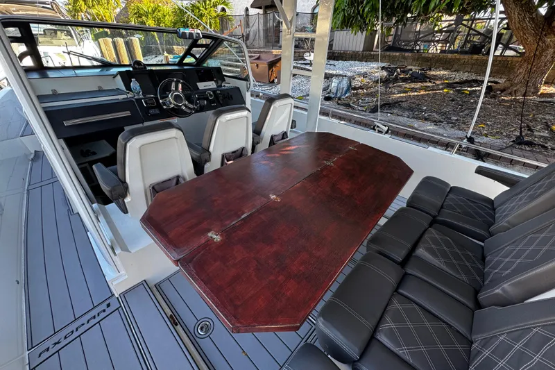  Yacht Photos Pics 2017 Axopar 37 Sun Top interior with steering console, seating, and wooden table.