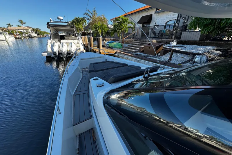  Yacht Photos Pics 2017 Axopar 37 Sun Top boat docked by waterfront property with lush greenery.