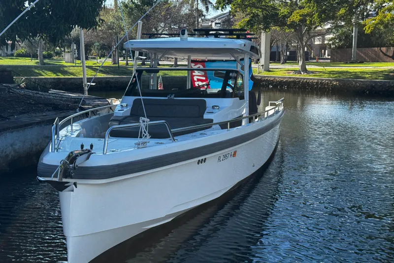  Yacht Photos Pics 2017 Axopar 37 Sun Top boat docked on a calm waterway.