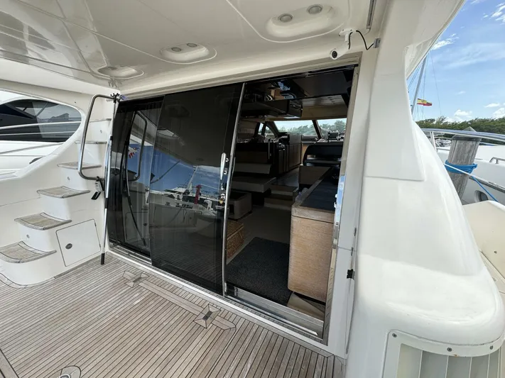Odyssey Yacht Photos Pics 2013 Azimut 64 Fly yacht interior view with sliding glass doors and wooden deck.