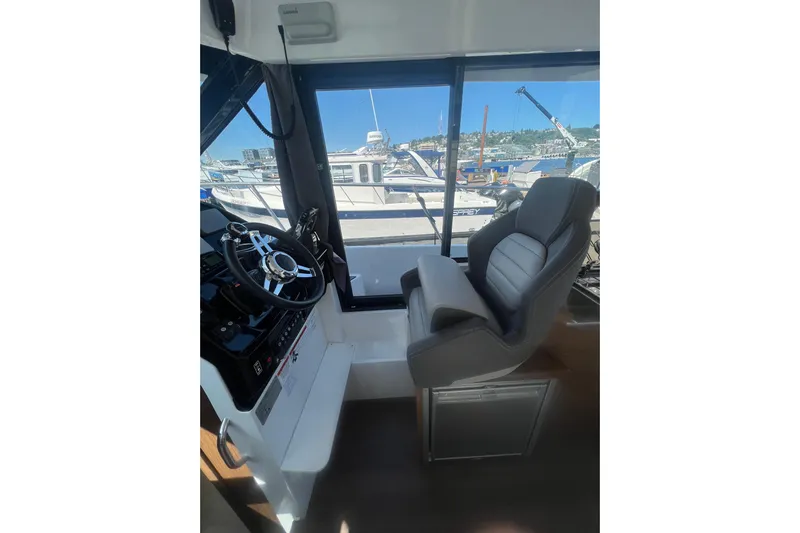  Yacht Photos Pics Interior view of 2018 Jeanneau NC 895 boat cockpit with steering wheel and captain's chair.