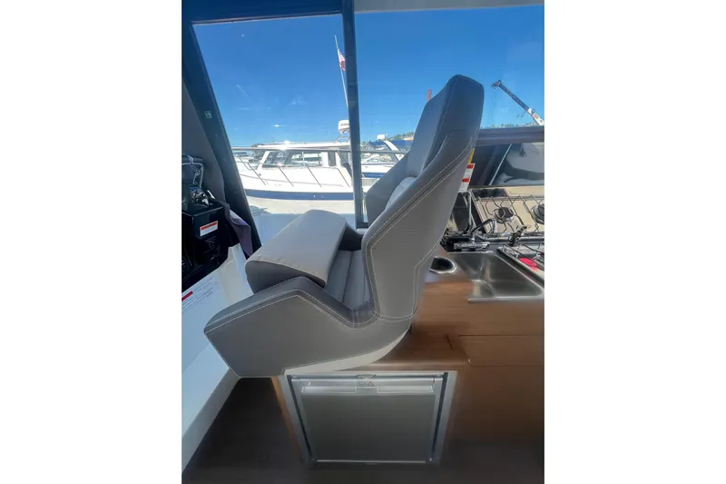  Yacht Photos Pics Captain's seat in 2018 Jeanneau NC 895 boat, featuring sleek design and modern controls.
