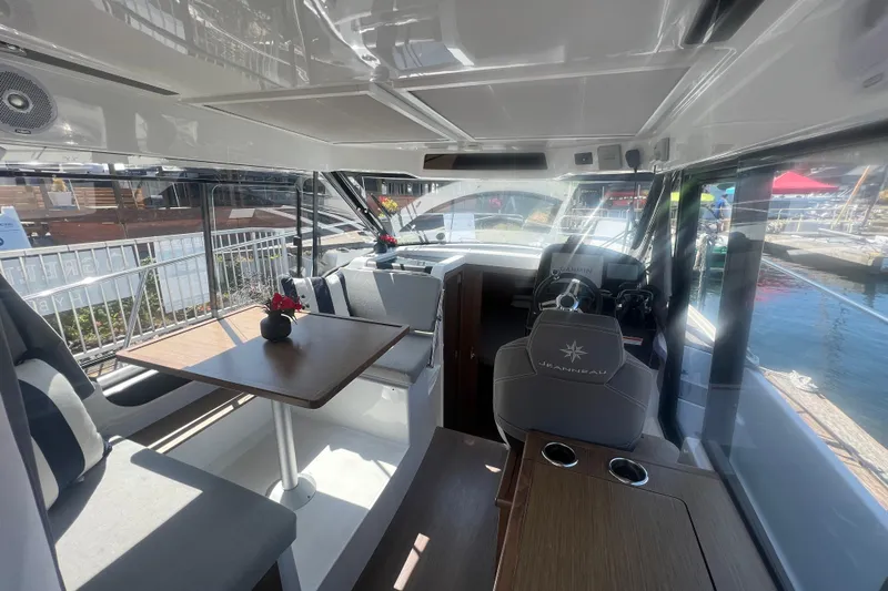  Yacht Photos Pics Interior of 2018 Jeanneau NC 895 boat with seating and helm, dockside view.