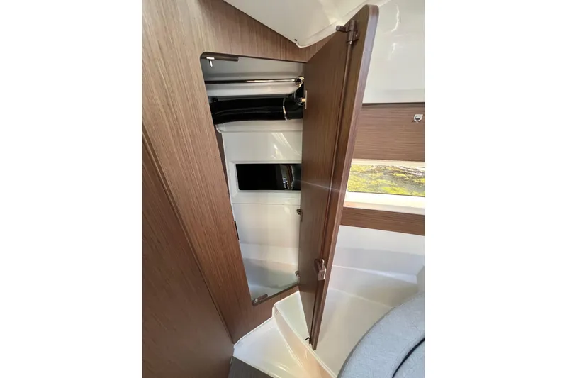  Yacht Photos Pics Interior view of 2018 Jeanneau NC 895 boat, featuring a wooden cabinet with a mirror.