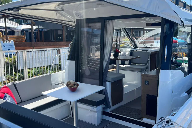  Yacht Photos Pics 2018 Jeanneau NC 895 boat interior with seating and table, docked at marina.