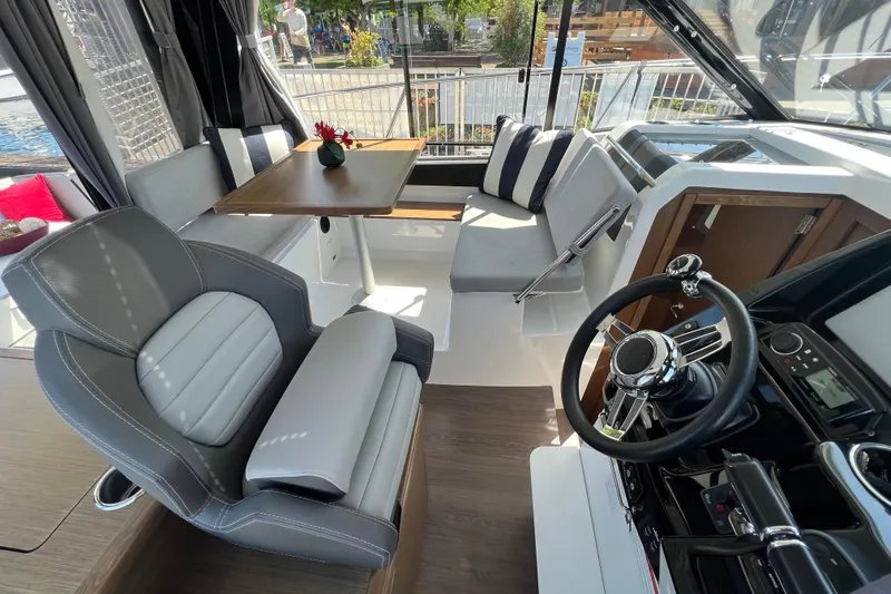  Yacht Photos Pics Interior of 2018 Jeanneau NC 895 boat with modern seating and steering wheel.