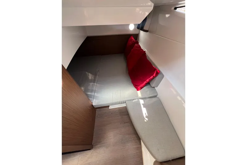  Yacht Photos Pics 2018 Jeanneau NC 895 cabin interior with gray cushions and red pillows.