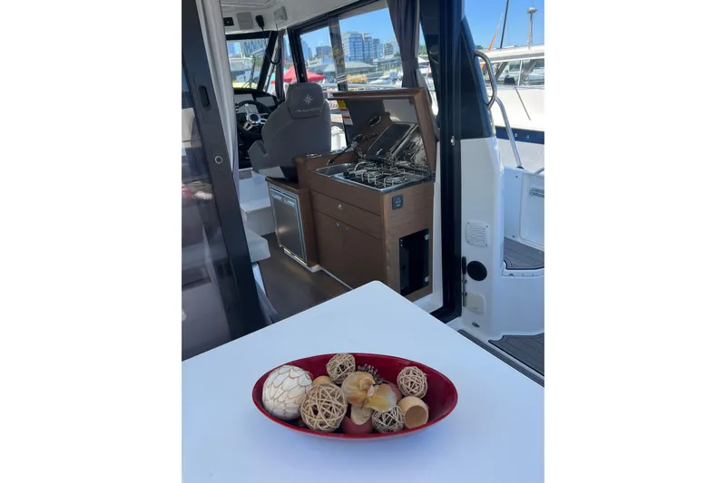  Yacht Photos Pics Interior of 2018 Jeanneau NC 895 boat with modern kitchen and decorative centerpiece.