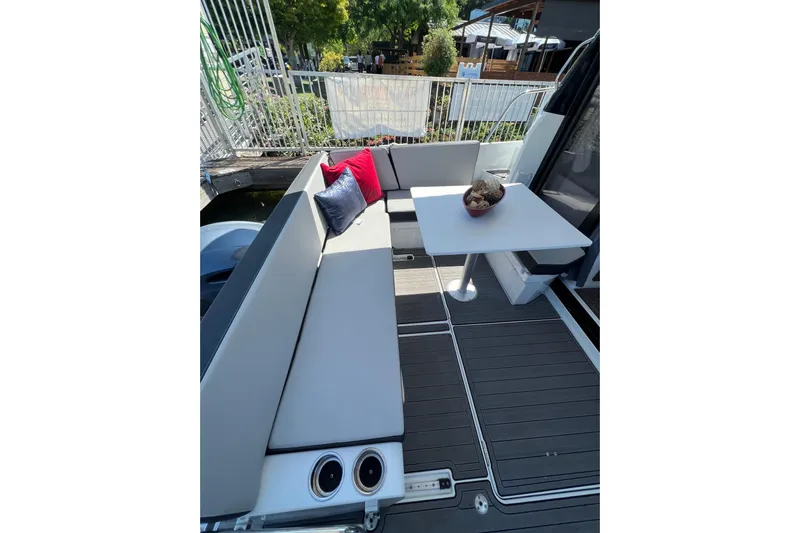  Yacht Photos Pics 2018 Jeanneau NC 895 boat deck with seating, table, and decorative cushions.