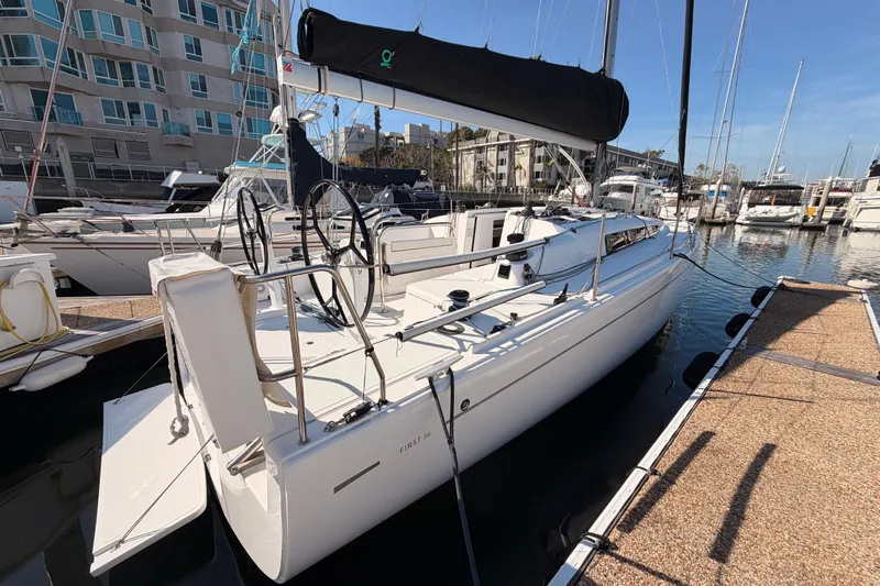 First 36 Yacht Photos Pics 2023 Beneteau First 36 sailboat docked in marina, showcasing sleek design and modern features.