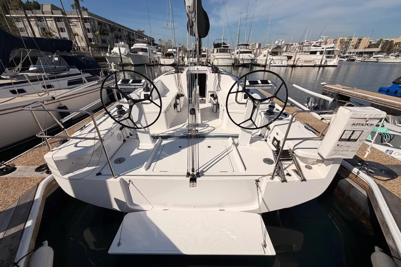 First 36 Yacht Photos Pics 2023 Beneteau First 36 sailboat docked at marina, featuring dual steering wheels.