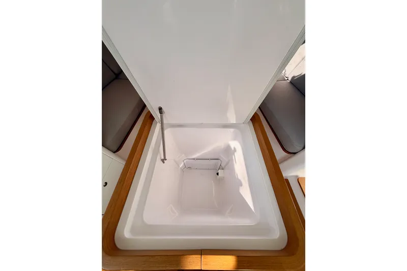 First 36 Yacht Photos Pics 2023 Beneteau First 36 interior storage compartment with wooden trim and seating area.