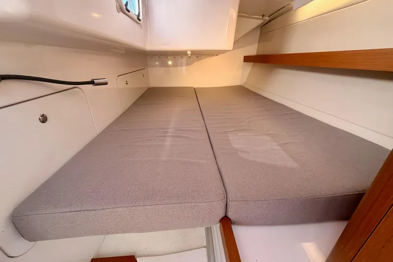 First 36 Yacht Photos Pics Interior cabin of 2023 Beneteau First 36 sailboat with cushioned sleeping area.