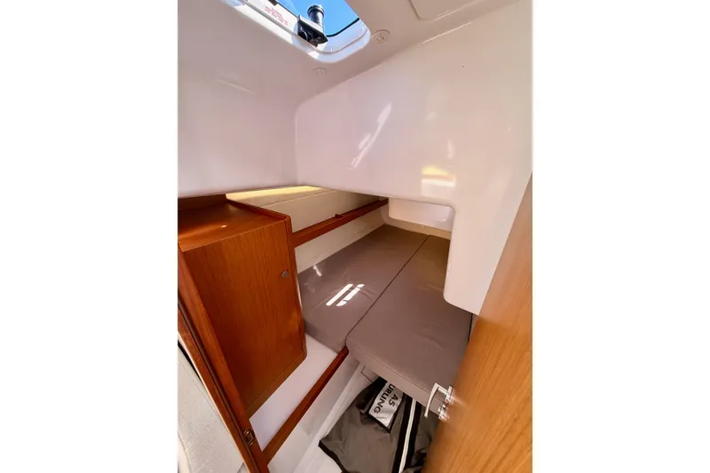 First 36 Yacht Photos Pics 2023 Beneteau First 36 cabin interior with wooden cabinetry and cozy sleeping area.