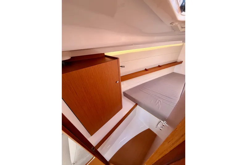 First 36 Yacht Photos Pics 2023 Beneteau First 36 interior cabin with wooden cabinetry and cozy sleeping area.