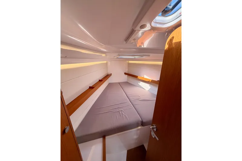 First 36 Yacht Photos Pics 2023 Beneteau First 36 cabin interior with cozy bed and wooden accents.