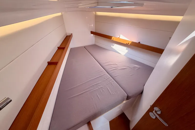 First 36 Yacht Photos Pics 2023 Beneteau First 36 cabin interior with cozy bed and wooden accents.