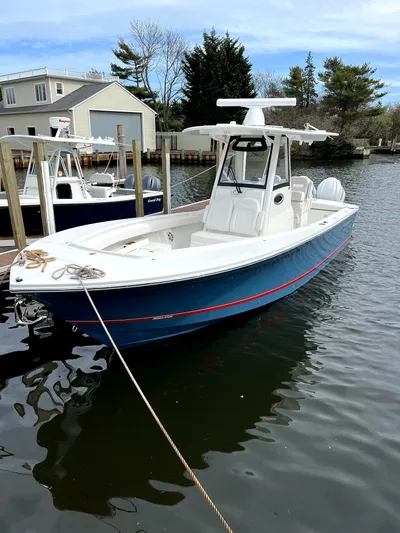  Yacht Photos Pics 2023 Regulator 28 boat docked in a marina, featuring a sleek blue hull and modern design.