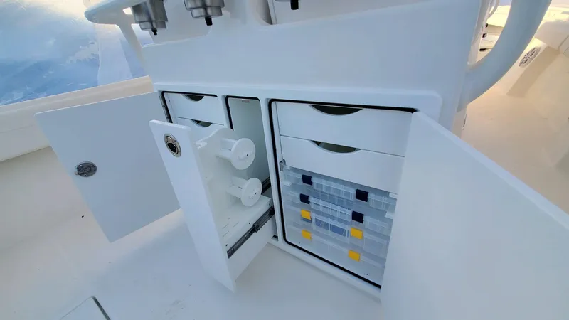 Yacht Photos Pics 2023 Regulator 28 boat storage compartments with open doors, showcasing organized interior.