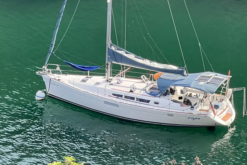 Flyer Yacht Photos Pics 2010 Jeanneau Sun Odyssey 44i sailboat anchored on calm green water.