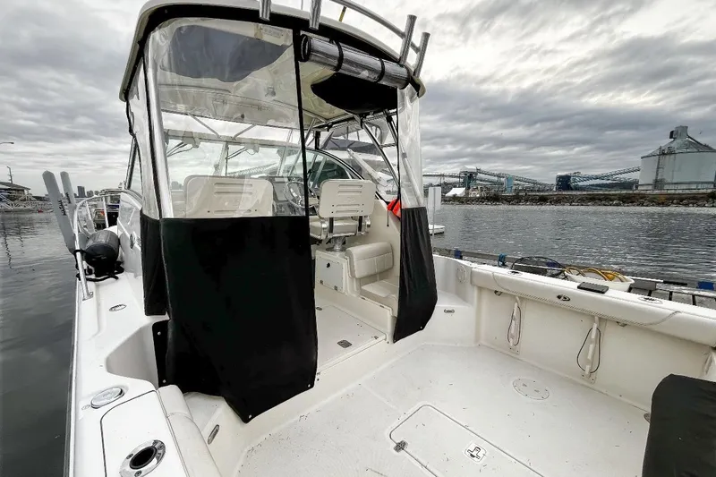  Yacht Photos Pics 2014 Pursuit OS 285 Offshore boat docked, featuring spacious deck and enclosed helm.