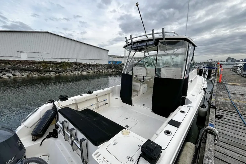  Yacht Photos Pics 2014 Pursuit OS 285 Offshore boat docked at marina under cloudy sky.