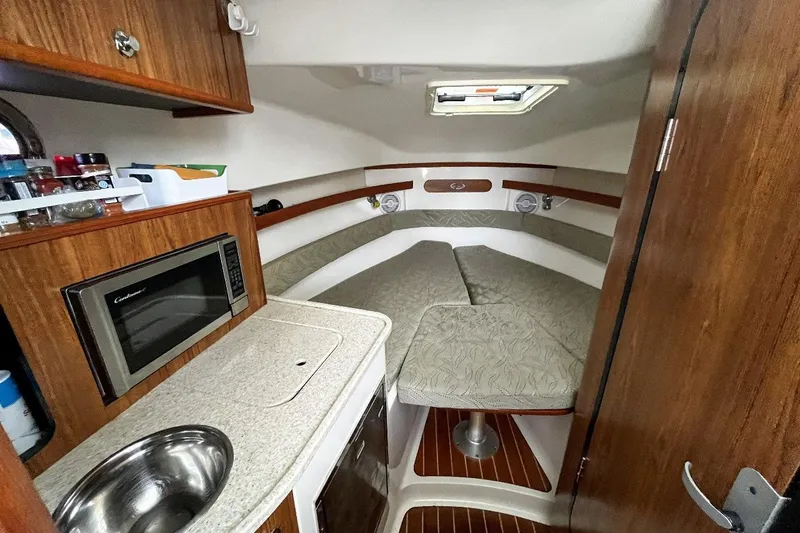  Yacht Photos Pics 2014 Pursuit OS 285 Offshore cabin with kitchenette and cozy sleeping area.