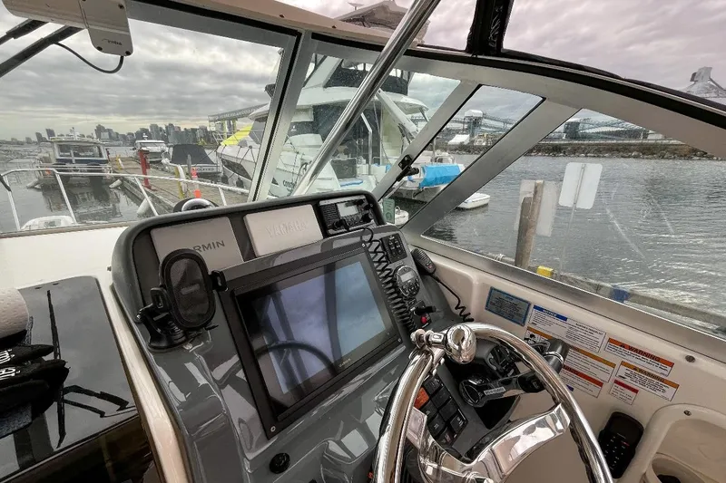  Yacht Photos Pics 2014 Pursuit OS 285 Offshore boat helm with navigation equipment at marina.