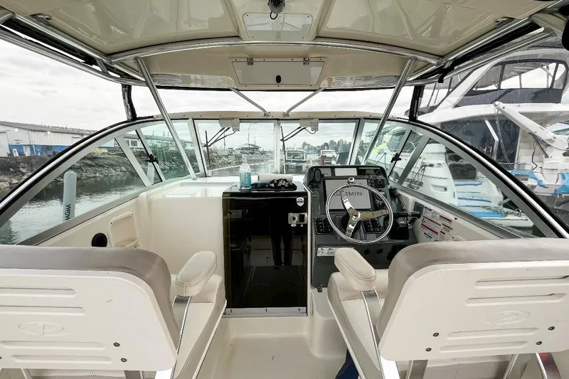  Yacht Photos Pics 2014 Pursuit OS 285 Offshore boat interior with steering wheel and dashboard view.