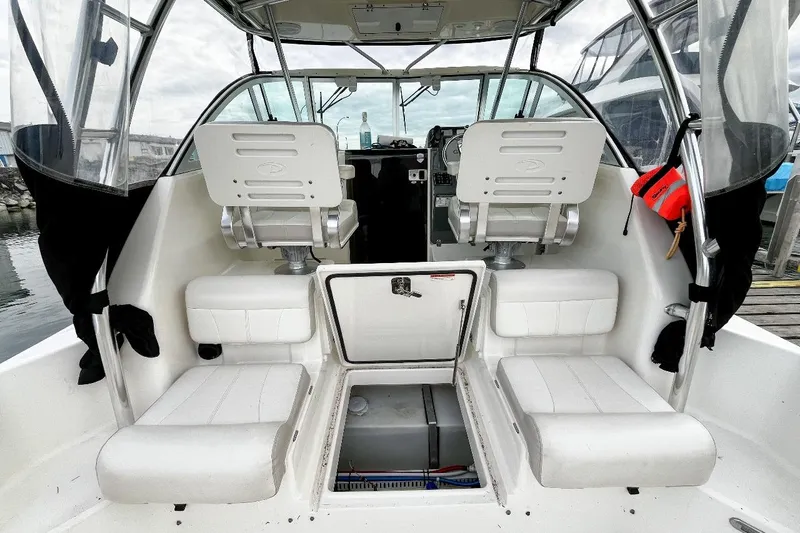  Yacht Photos Pics 2014 Pursuit OS 285 Offshore boat interior with seating and helm, docked at marina.