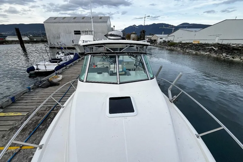  Yacht Photos Pics 2014 Pursuit OS 285 Offshore boat docked at marina with scenic mountain backdrop.